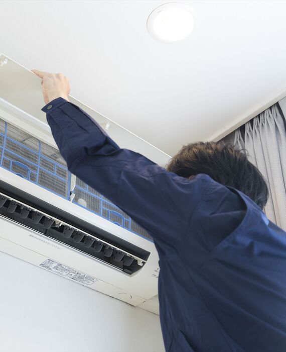 エアコンの点検をする男性スタッフ
