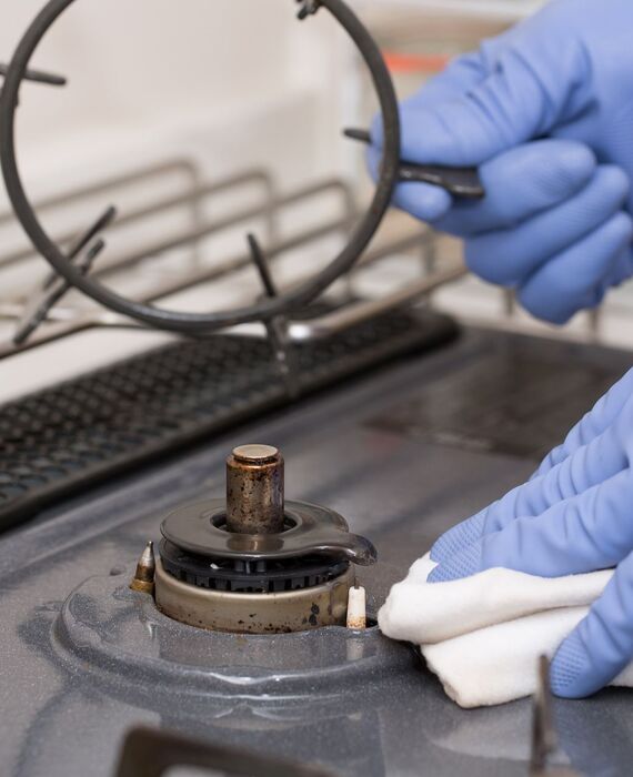 ガスレンジを掃除するスタッフ